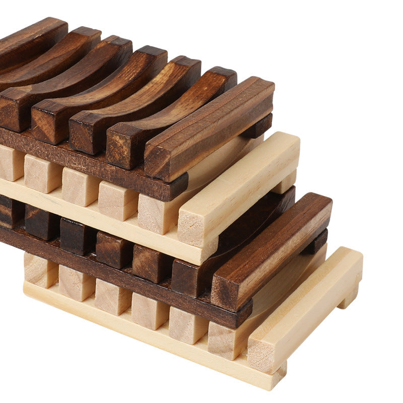 A stack of wooden soap dishes in alternating light and dark wood colors.